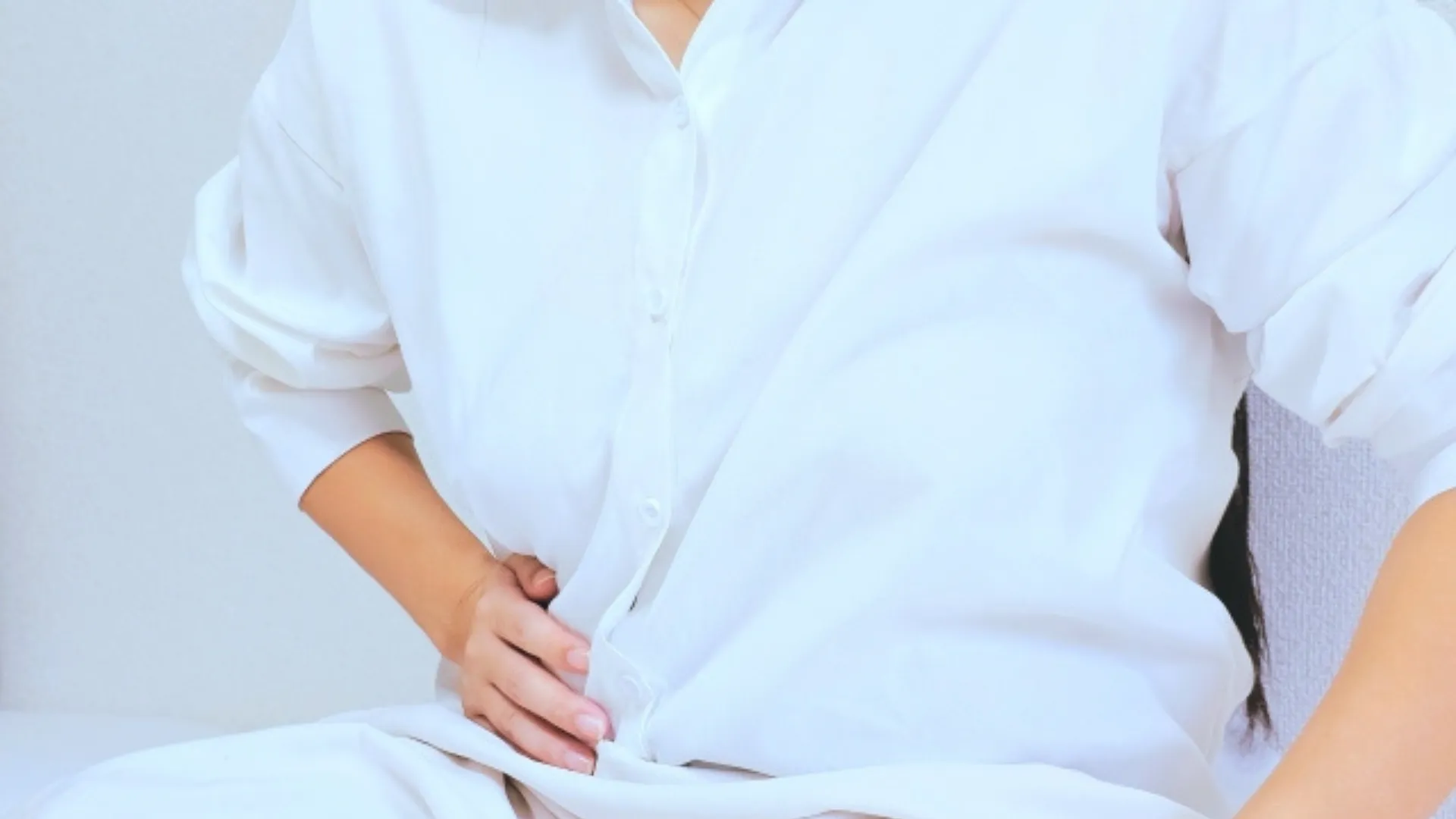 お腹に手を当てる女性
